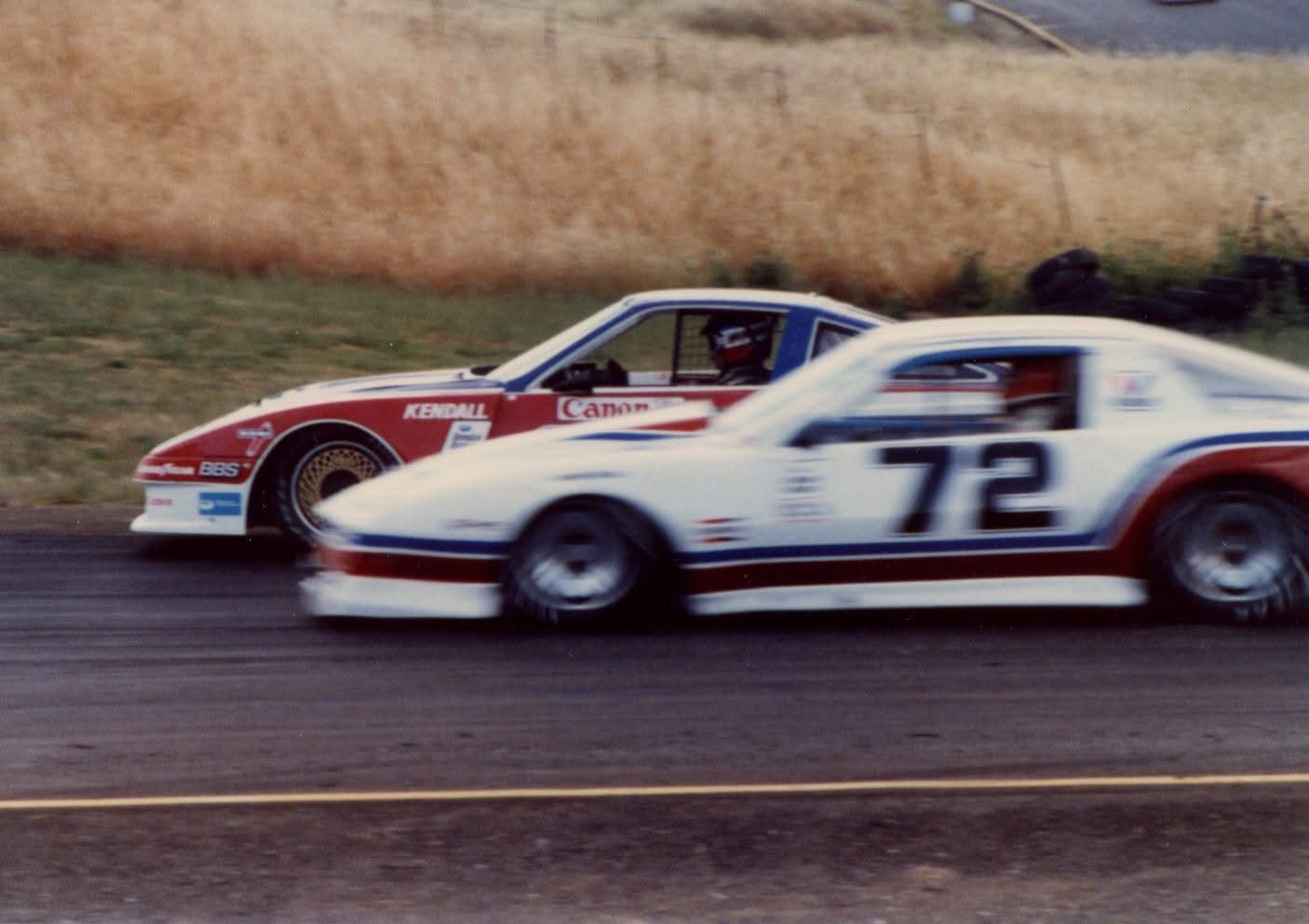 Bruce Jenner's striped #72 Pontiac side by side with a red, white and blue Kendall / Canon car