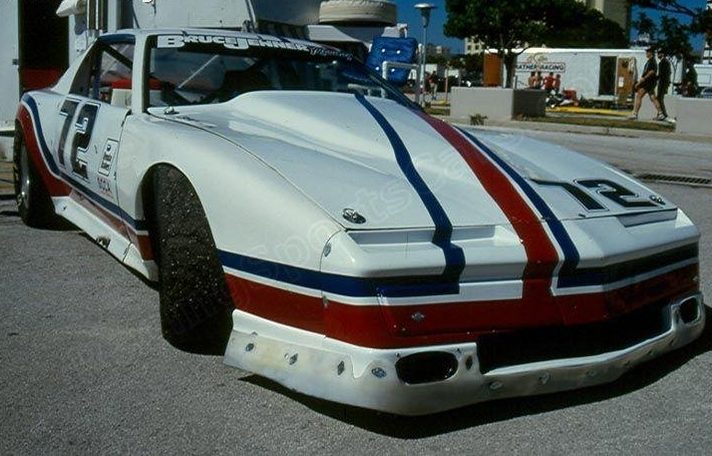 The striped 1982 Pontiac #72 in the paddock, Bruce Jenner Racing across the windscreen